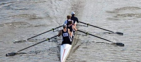 Men's coxless four racing towards the railway bridge